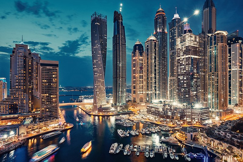 a city at night with boats in the water